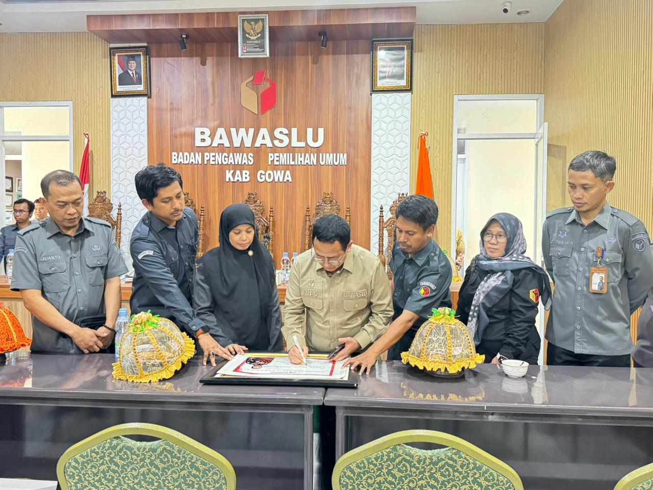 Dr. Puadi menuliskan kesan dan pesan dalam kunjungan monitoring supervisi di Sekretariat Bawaslu Kabupaten Gowa